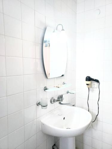 a white bathroom with a sink and a mirror at Kleopatra Sahara Hotel in Alanya