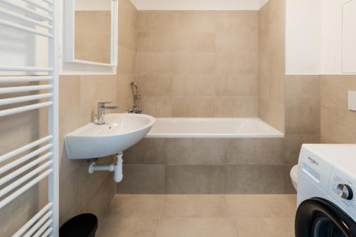 a bathroom with a sink and a bath tub at Urban & Green Apartments by Ambiente in Prievoz