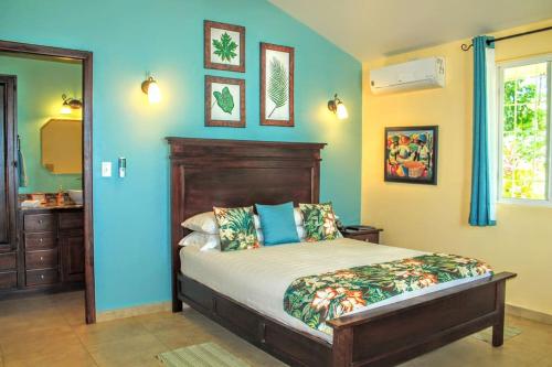 a bedroom with a bed and a blue wall at Las Casitas of Villa Paraiso / Beachfront & Pool in Big Creek