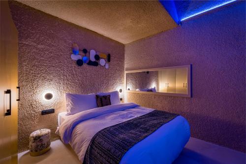 a bedroom with a large bed in a purple room at Canyon Santorini in Fira