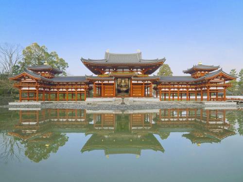 a large building sitting on top of a body of water at Hanayashiki Ukifune-en in Uji
