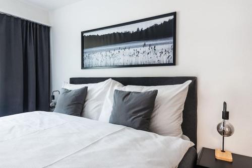 a bedroom with a white bed with a picture on the wall at Cooldis 12 !Gratis Parken, Free Parking! in Kreuzlingen