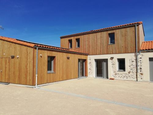a large building with two garages in a parking lot at LA BORDERIE - MAISON DES RANDONNEES - Gîte étape - gîte de groupe in Vairé