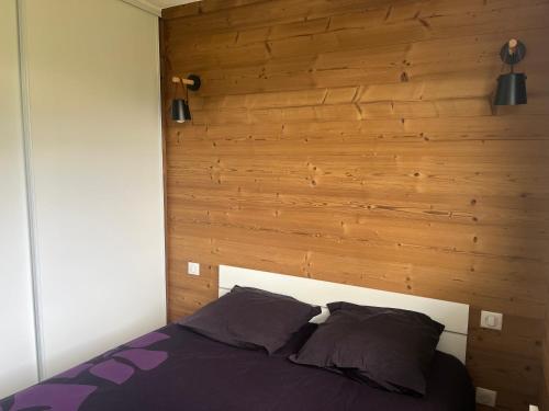une chambre avec un lit avec une tête de lit en bois dans l'établissement Serre Chevalier Chantemerle Appartement pour 4 personnes, Résidence les Mélèzes, à Saint-Chaffrey