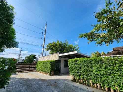a house with a hedge in front of a building at Villa Him Doi in Ban Mae Rim Nua
