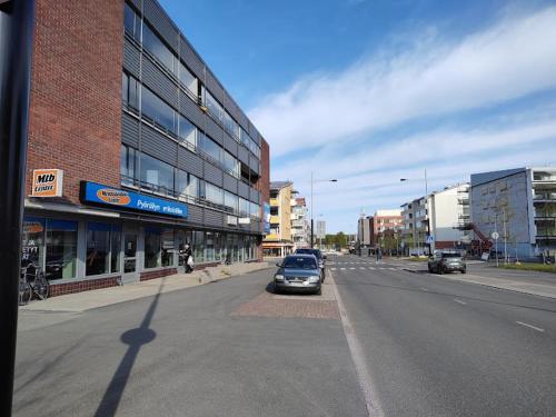 a car driving down a street in a city at Cozy Nest, apartement in the center of Rovaniemi in Rovaniemi