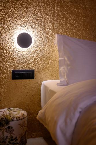 a bedroom with a bed with a light on the wall at Canyon Santorini in Fira