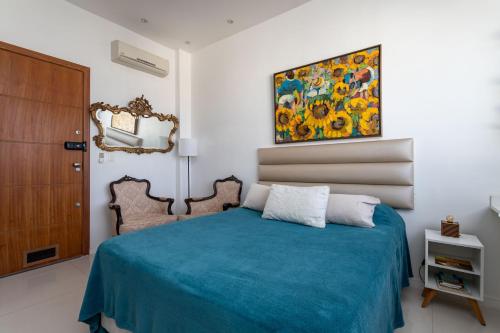 Un dormitorio con una cama azul y una pintura en la pared en Loft Catete, en Río de Janeiro