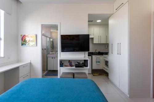 1 dormitorio blanco con 1 cama azul y cocina en Loft Catete, en Río de Janeiro