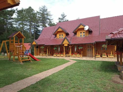 a log cabin with a playground in front of it at Vila Perisic in Kaludjerske Bare