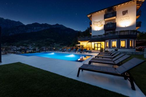 una villa con piscina di notte di Hotel Castel Mani a San Lorenzo in Banale