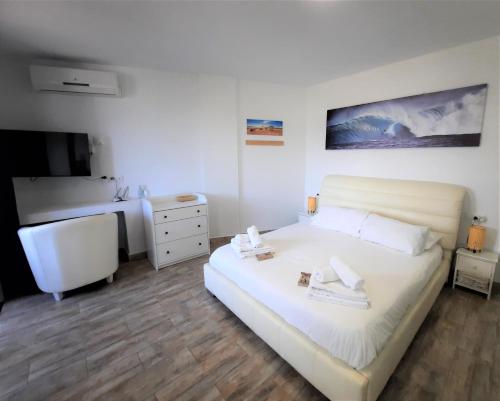 Schlafzimmer mit einem großen weißen Bett und einem Schreibtisch in der Unterkunft ZioCarlo/Las Americas in Playa de las Americas