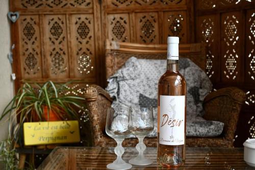 eine Flasche Wein auf einem Tisch mit zwei Gläsern in der Unterkunft Appartement romantique avec jacuzzi et terrasse in Perpignan