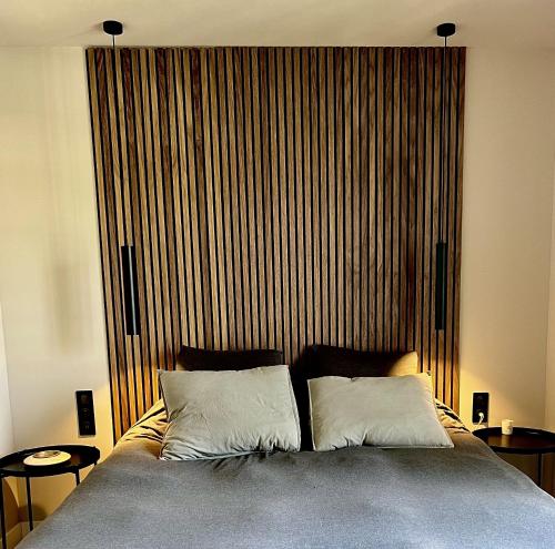 a bed with two pillows in front of a large window at Casa iKa Port Grimaud - Maison 4 chambres + amarrage in Grimaud