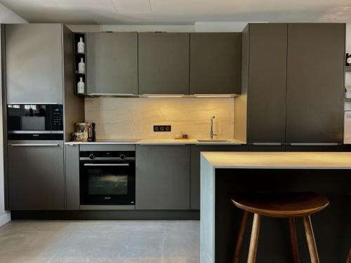 eine Küche mit grauen Schränken und einer Arbeitsplatte in der Unterkunft Casa iKa Port Grimaud - Maison 4 chambres + amarrage in Grimaud