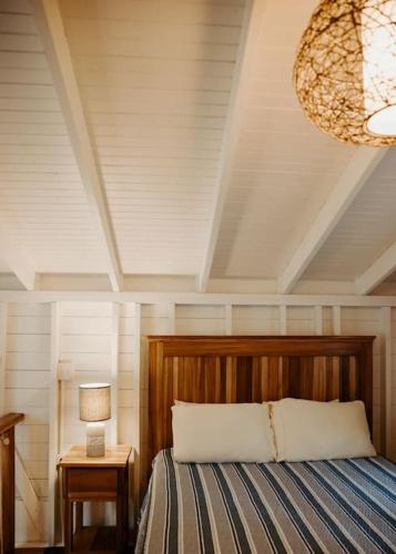 a bedroom with a bed and a lamp and a chandelier at CherryTree Bungalow of Villa Paraiso / Beachfront in Big Creek