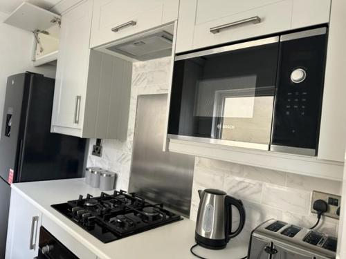 a kitchen with a stove and a microwave at Eva Suites in Gillingham