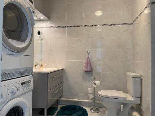 a bathroom with a toilet and a washing machine at Charming flat just outside Paris w free Private Parking in Saint-Ouen