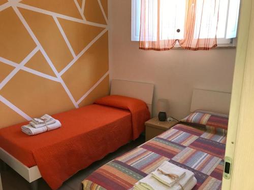 Dos camas en una habitación pequeña con toallas. en La Porta Del Sole, en Nova Siri Marina