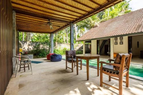 a patio with a table and chairs and a pool at VILLA Surya 3 rooms , waterpool, near the ocean in Candidasa