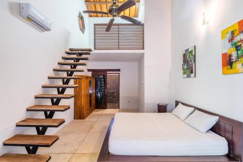 a bedroom with a bed and a spiral staircase at VILLA Surya 3 rooms , waterpool, near the ocean in Candidasa