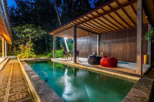 a swimming pool in a house with a pergola at VILLA Surya 3 rooms , waterpool, near the ocean in Candidasa