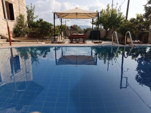 einen Pool mit einem Tisch und einem Sonnenschirm in der Unterkunft Hephaestus Villa in Kapparianá