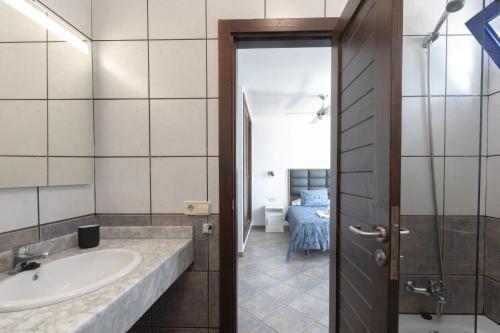 ein Bad mit einem Waschbecken und einem Spiegel in der Unterkunft Luxury 3-bedroom villa with private pool in Marina Rubicon, Playa Blanca, Lanzarote in Playa Blanca