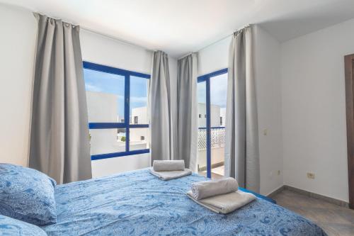 Un dormitorio con una cama con dos toallas encima. en Luxury 3-bedroom villa with heated private pool - in Marina Rubicon, Playa Blanca, Lanzarote, en Playa Blanca