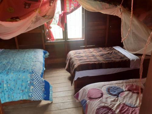 a bedroom with two beds and a window at Samaki Guesthouse - Tad Lo in Ban Donkhagnoung
