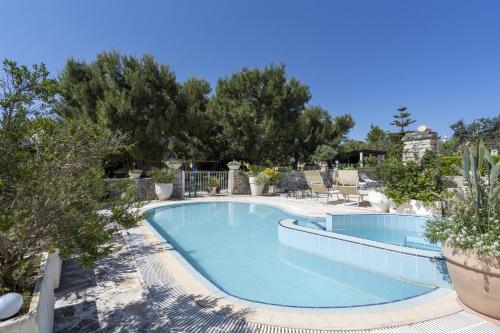 a swimming pool in a resort with trees at Agriturismo Salinola 3 in Ostuni