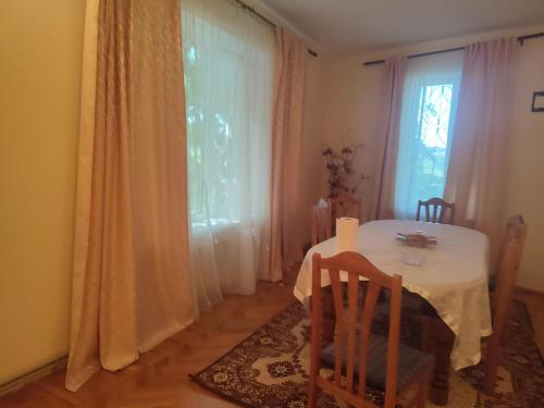 ein Esszimmer mit einem Tisch und einem Fenster in der Unterkunft Vila Tatiana in Bîc