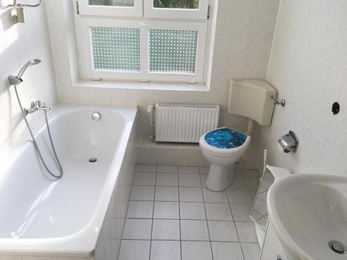 a bathroom with a tub and a toilet and a sink at Gemütliche Ferienwohnung für 6 Personen im Schloss Kastorf in Knorrendorf