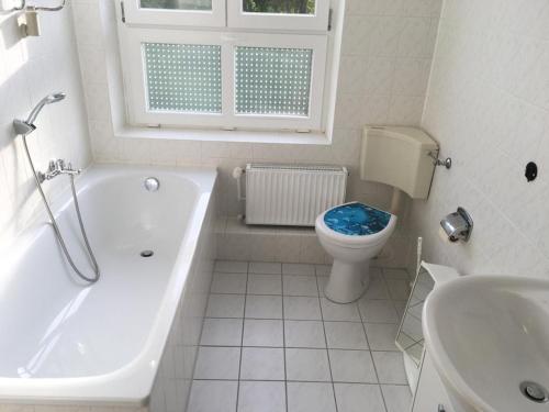un bagno con vasca, WC e lavandino di Gemütliche Ferienwohnung für 6 Personen im Schloss Kastorf a Knorrendorf