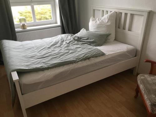 un letto non rifatto in una camera da letto con finestra di Gemütliche Ferienwohnung für 6 Personen im Schloss Kastorf a Knorrendorf