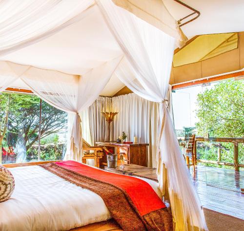 a bedroom with a bed with a canopy at Mara Leisure Camp in Talek