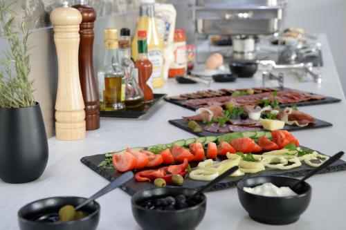 a buffet with several plates of food on a table at Premier Hotel Miskolc in Miskolc