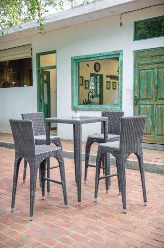 three chairs and a table with a mirror in front of a building at Tranquilisle in Kandy