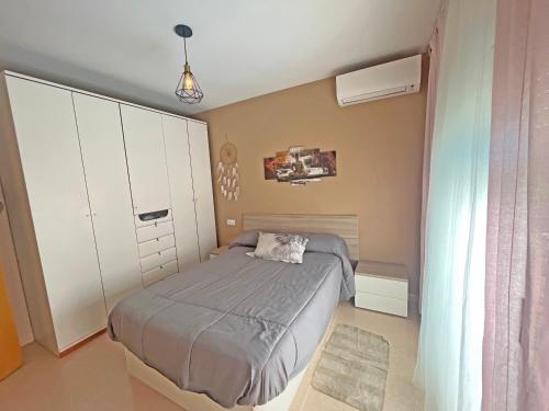 a bedroom with a bed and a white cabinet at CASA EN VILAFORTUNY CON BARBACOA PISCINA COMUNITARIa in Cambrils