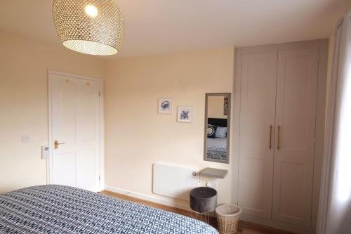 a bedroom with a bed and a lamp and a closet at Lovely two bed home in Cemaes, Anglesey in Cemaes Bay