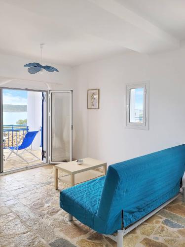 a blue couch in a living room with a view of the ocean at SempreViva Sea Houses in Dhiakofti