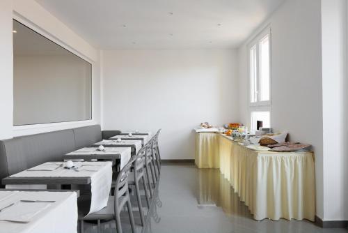 un comedor con mesas y sillas y una ventana en Hotel Cantoria en Florencia