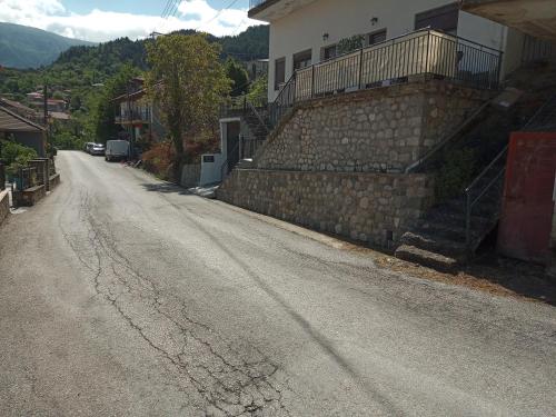 an empty street with a building and a stone wall at Tzoumerka Panorama in Pramanta