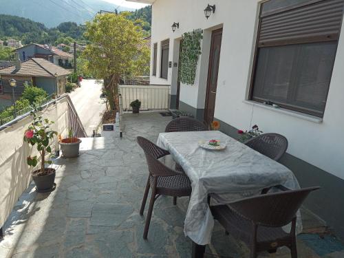 a patio with a table and chairs on a balcony at Tzoumerka Panorama in Pramanta