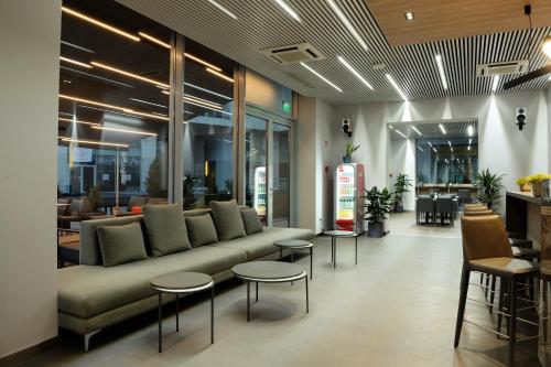 a lobby with a couch and some tables and chairs at Premier Hotel Miskolc in Miskolc