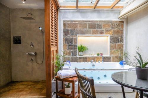 a bathroom with a bath tub and a table and chairs at Tranquilisle in Kandy