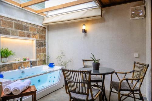 a bathroom with a tub and a table and chairs at Tranquilisle in Kandy