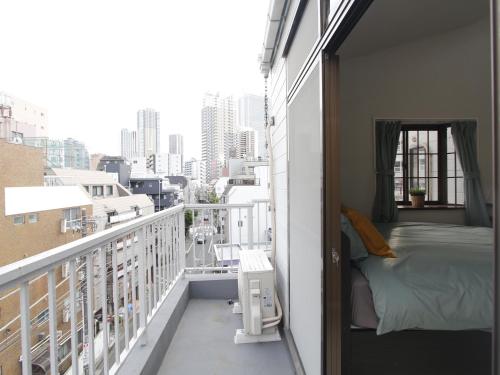 a small balcony with a bed and a view of a city at 渡邉ビル in Tokyo