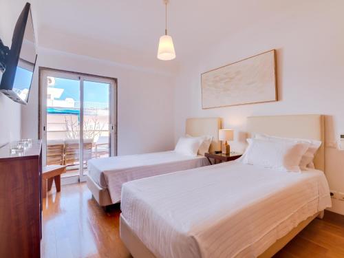 een hotelkamer met 2 bedden en een balkon bij AL - Quarteira Terrace Penthouse in Quarteira