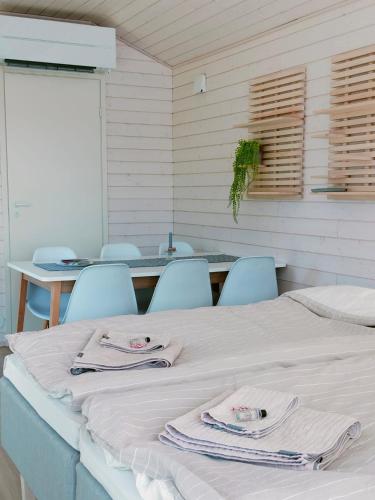 a room with a table and chairs with towels on a bed at Willa Rauha 2B in Lumijoki